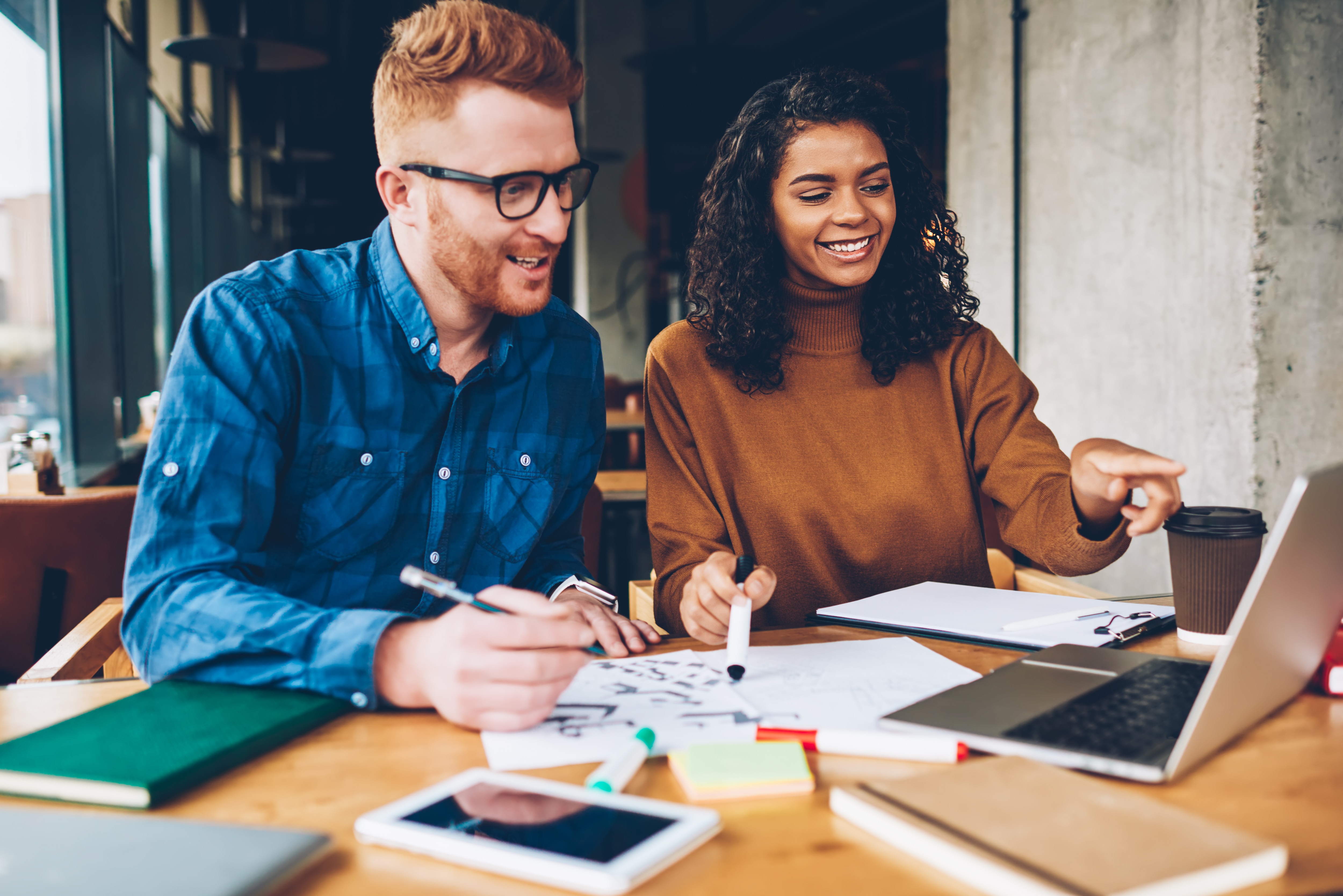 Two people smiling and working together