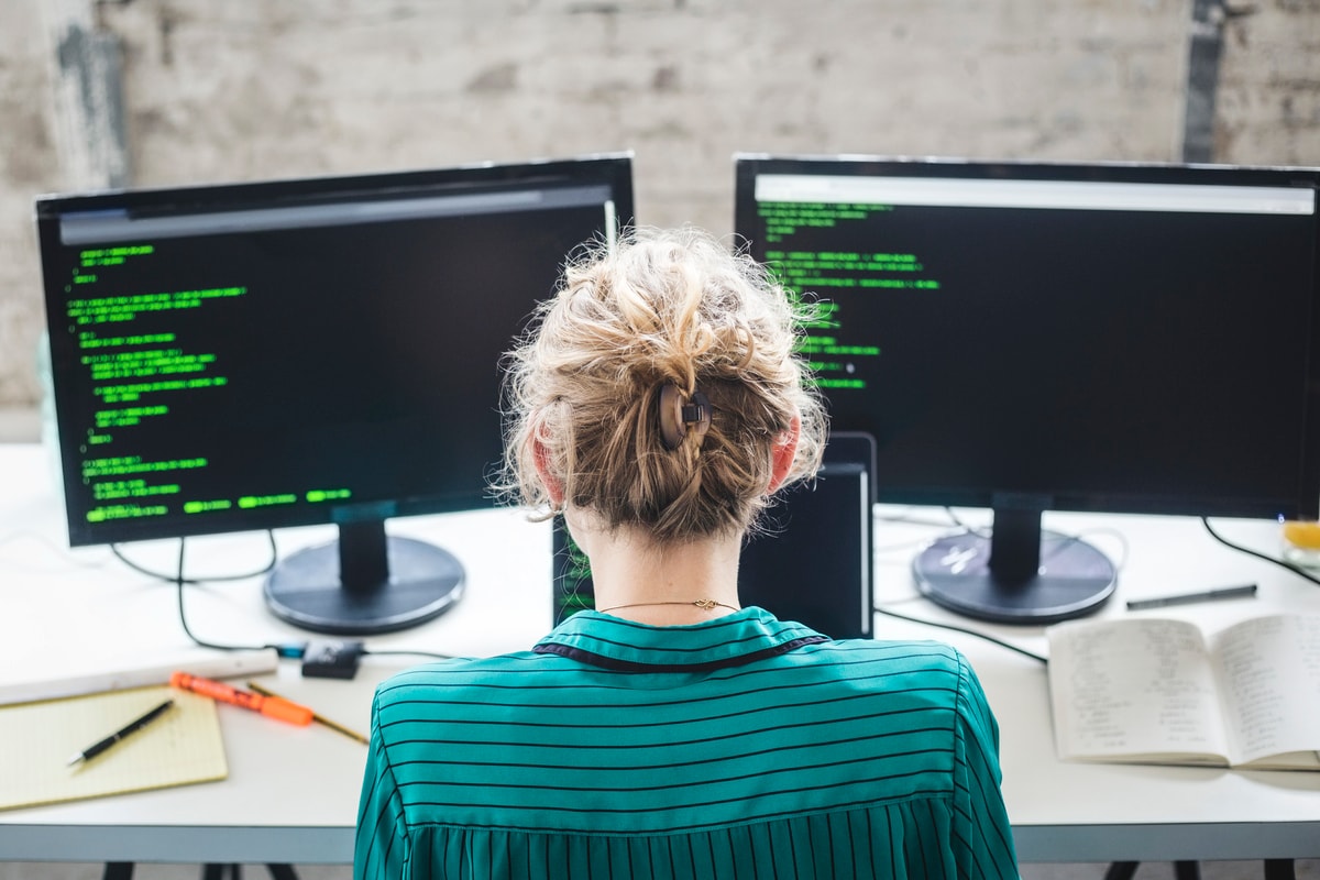 a woman in front of two computers